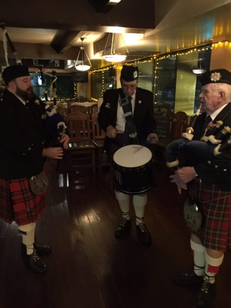 Two pipers and a drummer of the British Club Bangkok Pipe Band. Playing bagpipes and drums for the Siam Whisky CLub in Bangkok Thailand.