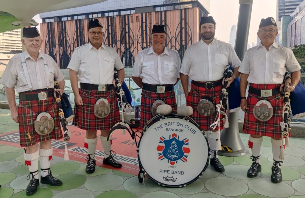 Members of the Bangkok Pipe band standing behind the bass drum, outside on a skywalk on a Sunday afternoon in Bangkok