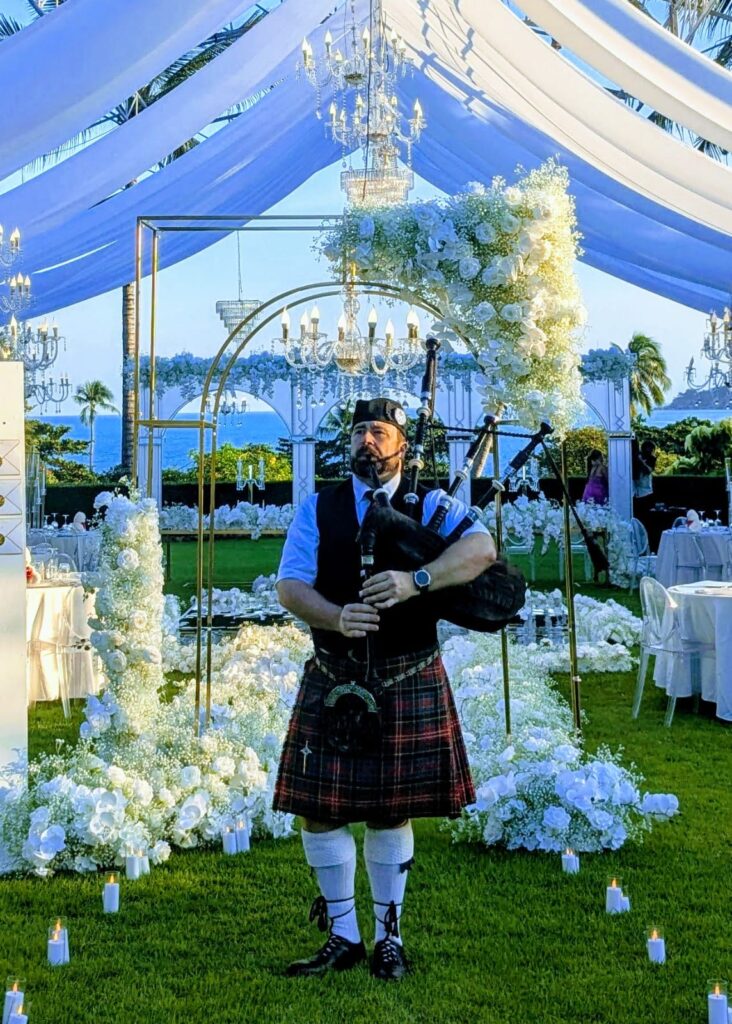 Bagpiper playing bagpipes in front of a wedding's reception area on Koh Samui. 