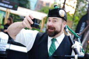 Bagpiper holds beer and bagpipes outside a Guinness event for St. Patrick's Day in Bangkok