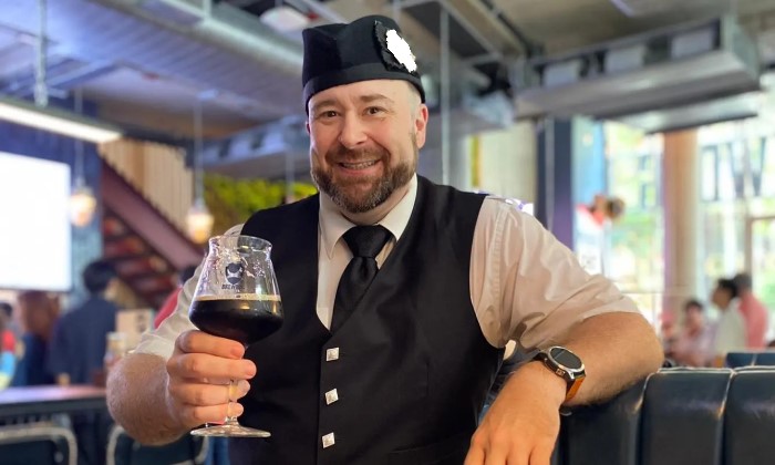 Bagpiper in Bangkok holding a stout